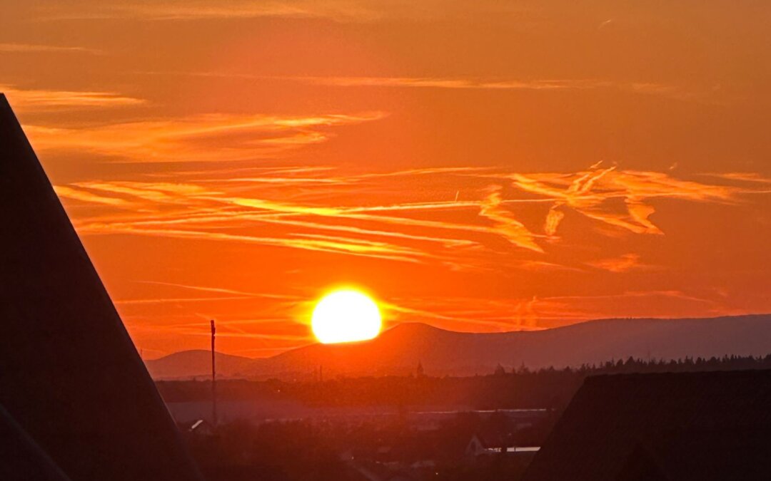 Unternehmerin blickt am Feierabend auf ein Abendrot hinter den Vogesen – Sinnbild für ein Unternehmen, das auch ohne sie trägt.