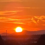Unternehmerin blickt am Feierabend auf ein Abendrot hinter den Vogesen – Sinnbild für ein Unternehmen, das auch ohne sie trägt.